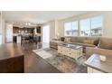 Bright open concept living room featuring hardwood floors, large windows, and comfortable seating at 9486 Juniper Way, Arvada, CO 80007