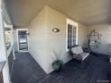 Cozy covered porch with hanging chair and neutral paint and dark wood flooring at 1354 Avgare Way, Erie, CO 80516