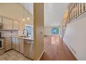 Modern kitchen featuring stainless steel appliances and adjacent hardwood floor living area at 5741 E 120Th Pl, Brighton, CO 80602