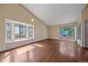 Bright living room with hardwood floors, large windows, and vaulted ceilings at 5741 E 120Th Pl, Brighton, CO 80602