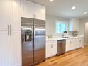 Kitchen with stainless steel fridge, white cabinets, quartz countertops, and stainless steel sink at 2090 S Clinton St, Denver, CO 80231