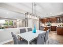 Bright dining room with modern light fixture open to the kitchen with seating for six at 2908 N Florence St, Denver, CO 80238