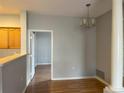 The dining room is bright with hard wood floors and a modern chandelier at 4054 S Crystal Cir # 103, Aurora, CO 80014