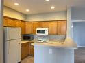 Traditional kitchen featuring wood cabinets, modern appliances, and a breakfast bar at 4054 S Crystal Cir # 103, Aurora, CO 80014