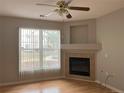 Cozy living room showcasing a fireplace, large windows, and a ceiling fan at 4054 S Crystal Cir # 103, Aurora, CO 80014