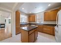 Spacious kitchen with wooden cabinets, center island, and view to living area at 1521 Vine St # 101, Denver, CO 80206