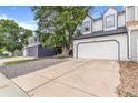 Street view of a home featuring a two-car garage, concrete driveway, and well-maintained landscaping at 3713 S Ensenada St, Aurora, CO 80013
