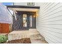 An inviting front entrance featuring a stone accent wall and modern black door at 3713 S Ensenada St, Aurora, CO 80013
