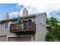 Exterior shot of a townhome with a brown balcony on the second story and an attached garage below at 1470 S Quebec Way # 245, Denver, CO 80231