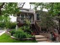 Inviting front entrance with a wooden porch and steps leading to a cozy brick home at 1470 S Quebec Way # 245, Denver, CO 80231