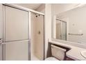 A clean and simple bathroom with a sliding glass door shower and neutral tones at 18091 E Kentucky Ave # 202, Aurora, CO 80017