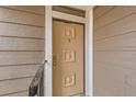 Close-up of the front door with decorative panels and a bronze door knob at 18091 E Kentucky Ave # 202, Aurora, CO 80017