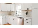 Updated kitchen featuring white cabinets, stainless steel dishwasher, and modern fixtures at 930 S Lowell Blvd, Denver, CO 80219