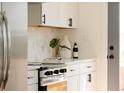 Kitchen counter with white cabinets, black hardware, and stylish decor at 930 S Lowell Blvd, Denver, CO 80219