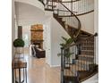 Grand foyer showcasing a curved staircase, wood floors, and view of the fireplace in the living room at 11999 S Stroll Ln, Parker, CO 80138