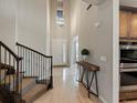 Bright foyer with soaring ceilings, wood floors, an elegant pendant lights and access to the kitchen at 11999 S Stroll Ln, Parker, CO 80138