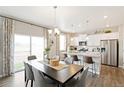 Open-concept kitchen and dining area with stainless steel appliances and modern light fixtures at 6543 13Th St, Frederick, CO 80530