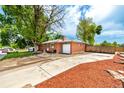 Lovely brick home featuring an extended driveway, lush trees, and a fenced backyard at 6598 S Logan St, Centennial, CO 80121