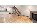Bright, spacious living room featuring hardwood floors, a staircase, and fireplace, great for gatherings at 11155 W 17Th Ave # 103, Lakewood, CO 80215