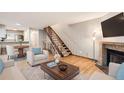Open-concept living room with hardwood floors, a fireplace, and a staircase leading to the upper level at 11155 W 17Th Ave # 103, Lakewood, CO 80215