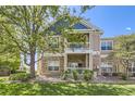Inviting two-story townhome with stone accents, a covered porch and an upper balcony providing outdoor spaces at 3375 Boulder Cir # 204, Broomfield, CO 80023