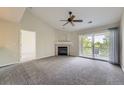 Bright living room featuring plush carpeting, a cozy fireplace, and sliding glass doors to the balcony at 3375 Boulder Cir # 204, Broomfield, CO 80023