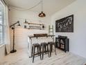 Stylish bar area features a unique counter with seating, decorative shelves, and modern lighting at 8367 Devinney St, Arvada, CO 80005