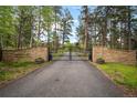Elegant gated entrance with stone pillars and manicured landscaping welcomes you home at 23076 Oehlmann Park Rd, Conifer, CO 80433