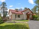 Charming home featuring a cozy front porch, well-maintained lawn, and inviting curb appeal at 23076 Oehlmann Park Rd, Conifer, CO 80433