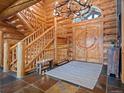 Grand log home foyer featuring a stunning staircase, antler chandelier, and custom woodwork at 23076 Oehlmann Park Rd, Conifer, CO 80433