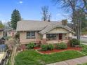 Charming brick home with a well-maintained lawn and inviting front porch nestled in a desirable neighborhood at 3242 Utica St, Denver, CO 80212