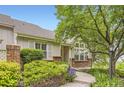 Charming home featuring mature landscaping, brick accents, and a welcoming walkway to the front door at 2980 W Long Dr # E, Littleton, CO 80120