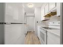 White kitchen with appliances and light wood flooring at 1170 S Troy St, Aurora, CO 80012