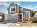 Charming two-story home boasts a two-car garage, brick accents, and a well-manicured front yard at 13755 W Amherst Way, Lakewood, CO 80228