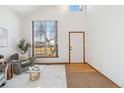 Inviting living room features vaulted ceilings, large windows, and neutral decor that creates a bright, airy atmosphere at 13755 W Amherst Way, Lakewood, CO 80228