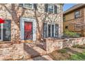 Close-up of the brick home's red front door, front porch and chairs at 2060 Ash St, Denver, CO 80207