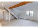 Open living room with a staircase, large window, and neutral carpet at 4877 Darwin Ct, Boulder, CO 80301