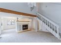 Bright living room featuring a fireplace, wood beam, staircase, and ample natural light at 4877 Darwin Ct, Boulder, CO 80301
