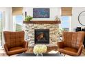 Warm living room with a beautiful stone fireplace and ample natural light at 4706 Mesa Top Dr, Monument, CO 80132