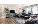 Well-lit living room featuring a modern entertainment center, large window, and comfortable seating at 7937 Chase Cir # 176, Arvada, CO 80003