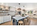 Bright kitchen boasts a large island with seating, modern appliances, and stylish pendant lighting at 5872 Taft St, Arvada, CO 80004