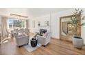 Inviting living room with a cozy fireplace, hardwood floors, and ample natural light, adjoining dining area at 5872 Taft St, Arvada, CO 80004