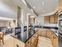 Spacious kitchen featuring granite countertops, wooden cabinets, and a central island cooktop at 5130 Morning Glory Pl, Highlands Ranch, CO 80130