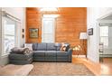 Cozy living room featuring hardwood floors, a comfortable gray sectional sofa, and a stylish accent wall at 3521 W 40Th Ave, Denver, CO 80211