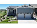 Charming home featuring a two-car garage, covered porch, and attractive landscaping at 22674 E Henderson Dr, Aurora, CO 80016