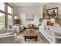 Comfortable living room with neutral tones, large windows, and a decorative rug at 1654 Muirfield Ln, Evergreen, CO 80439