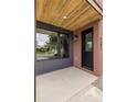 Charming covered porch with brick accents and modern black door at 4301 at 4301 Osceola St, Denver, CO 80212