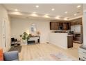 Open-concept living area with wood floors and a partial view of the kitchen at 16102 E 47Th Pl, Denver, CO 80239