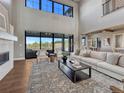 Bright open living room with large windows, fireplace, and stylish decor at 2690 Fox View Trl, Franktown, CO 80116