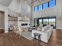 Bright living room with a fireplace, expansive windows, and modern furnishings, creating an inviting atmosphere at 2690 Fox View Trl, Franktown, CO 80116